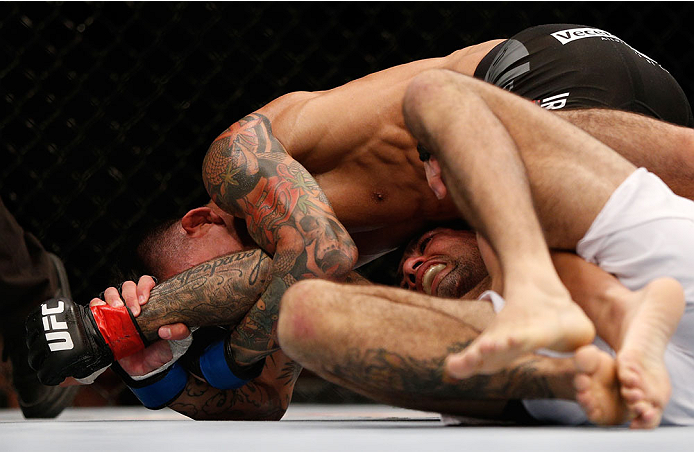 SINGAPORE - JANUARY 04: Russell Doane (top) attempts to secure an arm lock submission against Leandro Issa in their bantamweight bout during the UFC Fight Night event at the Marina Bay Sands Resort on January 4, 2014 in Singapore. (Photo by Josh Hedges/Z