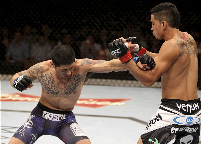 SINGAPORE - JANUARY 04: (L and R) Jon Delos Reyes throws a punch to Dustin Kimura in their bantamweight bout during the UFC Fight Night event at the Marina Bay Sands Resort on January 4, 2014 in Singapore. (Photo by Mitch Viquez/Zuffa LLC/Zuffa LLC via Ge
