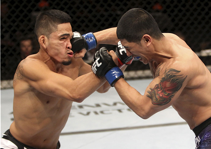 SINGAPORE - JANUARY 04: (R toL) Dustin Kimura lands a punch on Jon Delos Reyes in their bantamweight bout during the UFC Fight Night event at the Marina Bay Sands Resort on January 4, 2014 in Singapore. (Photo by Mitch Viquez/Zuffa LLC/Zuffa LLC via Gett
