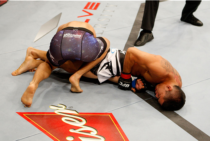 SINGAPORE - JANUARY 04: (L to R) Jon Delos Reyes tries to avoid a submission by Dustin Kimura in their bantamweight bout during the UFC Fight Night event at the Marina Bay Sands Resort on January 4, 2014 in Singapore. (Photo by Mitch Viquez/Zuffa LLC/Zu