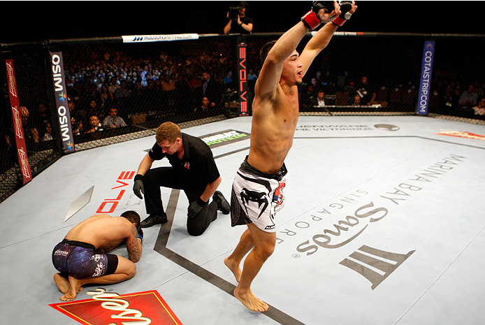 SINGAPORE - JANUARY 04: Dustin Kimura celebrates his win over Jon Delos Reyes in their bantamweight bout during the UFC Fight Night event at the Marina Bay Sands Resort on January 4, 2014 in Singapore. (Photo by Mitch Viquez/Zuffa LLC/Zuffa LLC via Getty