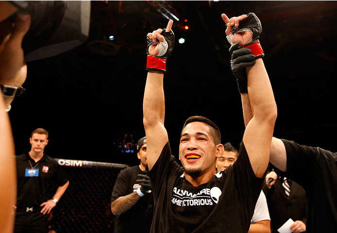 SINGAPORE - JANUARY 04: Dustin Kimura celebrates his win over Jon Delos Reyes in their bantamweight bout during the UFC Fight Night event at the Marina Bay Sands Resort on January 4, 2014 in Singapore. (Photo by Mitch Viquez/Zuffa LLC/Zuffa LLC via Getty