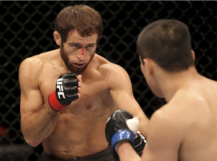 SINGAPORE - JANUARY 04: (L to R) Mairbek Taisumov faces off with Bang Tae Hyun in their lightweight bout during the UFC Fight Night event at the Marina Bay Sands Resort on January 4, 2014 in Singapore. (Photo by Mitch Viquez/Zuffa LLC/Zuffa LLC via Getty
