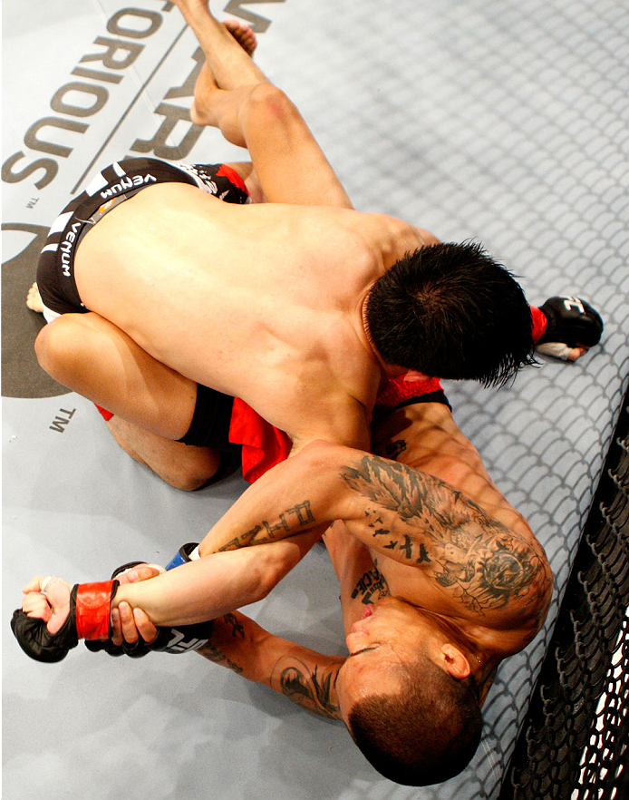 SINGAPORE - JANUARY 04: David Galera goes for a submission attempt on Royston Wee in their bantamweight bout during the UFC Fight Night event at the Marina Bay Sands Resort on January 4, 2014 in Singapore. (Photo by Mitch Viquez/Zuffa LLC/Zuffa LLC via G