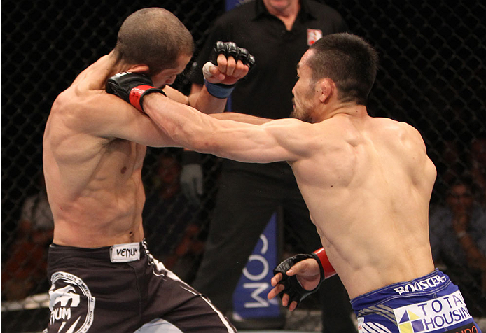 SINGAPORE - JANUARY 04: Katsunori Kikuno lands a punch on Quinn Mulhern in their lightweight bout during the UFC Fight Night event at the Marina Bay Sands Resort on January 4, 2014 in Singapore. (Photo by Mitch Viquez/Zuffa LLC/Zuffa LLC via Getty Images)