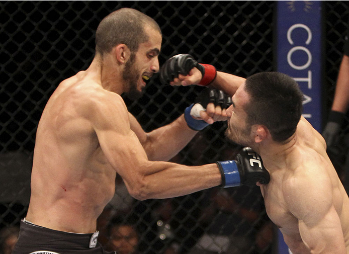 SINGAPORE - JANUARY 04: (L to R) Quinn Mulhern and Katsunori Kikuno both throw punches in their lightweight bout during the UFC Fight Night event at the Marina Bay Sands Resort on January 4, 2014 in Singapore. (Photo by Mitch Viquez/Zuffa LLC/Zuffa LLC v