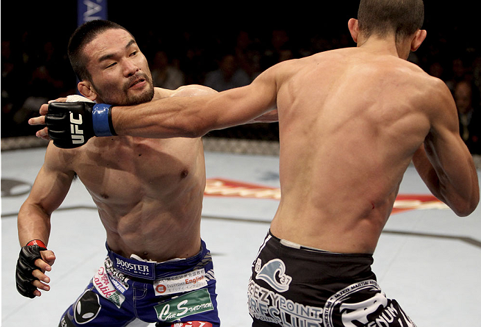 SINGAPORE - JANUARY 04: Katsunori Kikuno goes for a punch on Quinn Mulhern in their lightweight bout during the UFC Fight Night event at the Marina Bay Sands Resort on January 4, 2014 in Singapore. (Photo by Mitch Viquez/Zuffa LLC/Zuffa LLC via Getty Ima