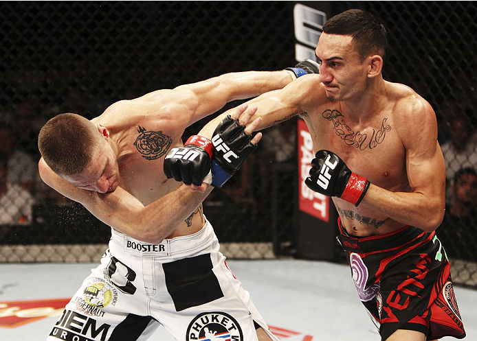 SINGAPORE - JANUARY 04: Max Holloway throws a punch at Will Chope in their featherweight bout during the UFC Fight Night event at the Marina Bay Sands Resort on January 4, 2014 in Singapore. (Photo by Mitch Viquez/Zuffa LLC/Zuffa LLC via Getty Images)