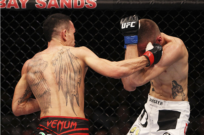 SINGAPORE - JANUARY 04: Max Holloway throws a punch at Will Chope in their featherweight bout during the UFC Fight Night event at the Marina Bay Sands Resort on January 4, 2014 in Singapore. (Photo by Mitch Viquez/Zuffa LLC/Zuffa LLC via Getty Images)