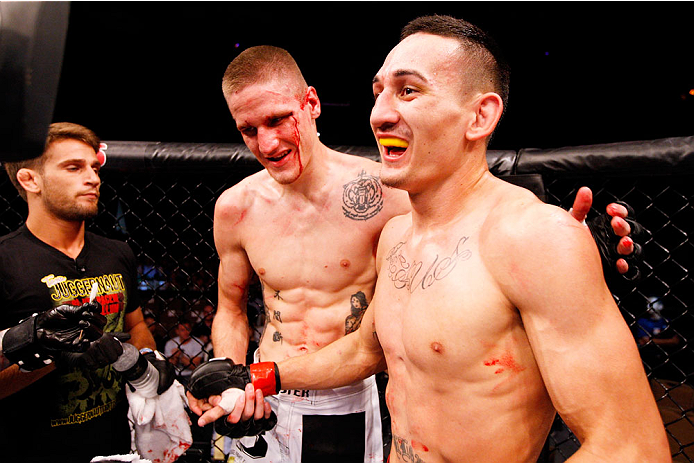 SINGAPORE - JANUARY 04: (L to R) Will Chope and Max Holloway come together after their featherweight bout during the UFC Fight Night event at the Marina Bay Sands Resort on January 4, 2014 in Singapore. (Photo by Mitch Viquez/Zuffa LLC/Zuffa LLC via Gett
