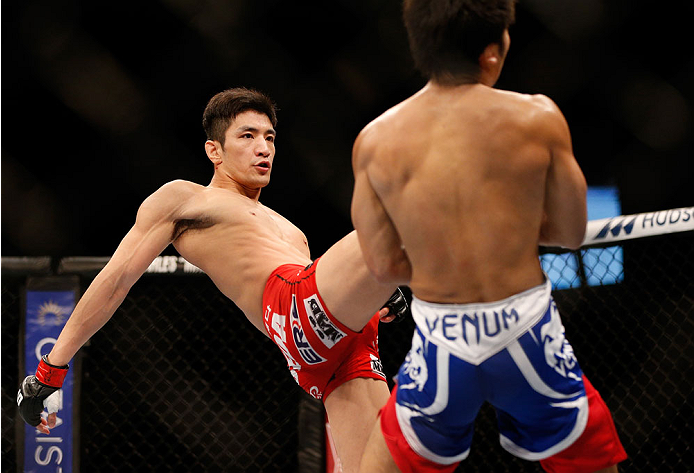 SINGAPORE - JANUARY 04: (L-R) Kang Kyung Ho kicks Shunichi Shimizu in their bantamweight bout during the UFC Fight Night event at the Marina Bay Sands Resort on January 4, 2014 in Singapore. (Photo by Josh Hedges/Zuffa LLC/Zuffa LLC via Getty Images)