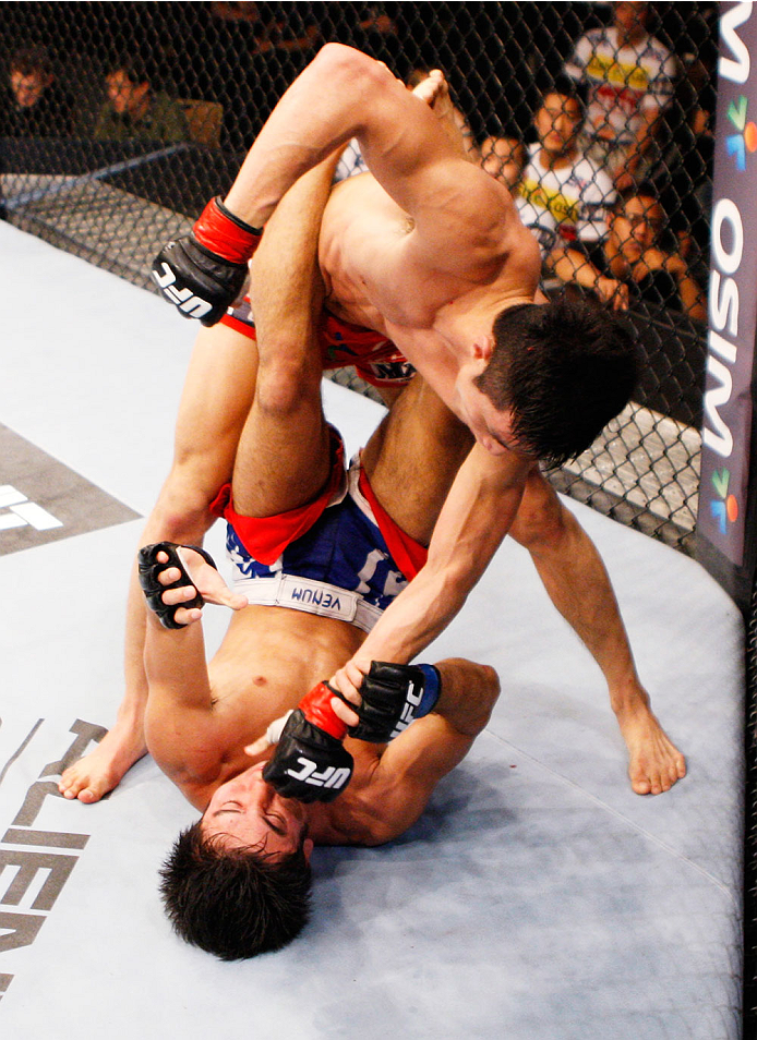 SINGAPORE - JANUARY 04: Kang Kyung Ho lands a punch on Shunichi Shimizu in their bantamweight bout during the UFC Fight Night event at the Marina Bay Sands Resort on January 4, 2014 in Singapore. (Photo by Mitch Viquez/Zuffa LLC/Zuffa LLC via Getty Images