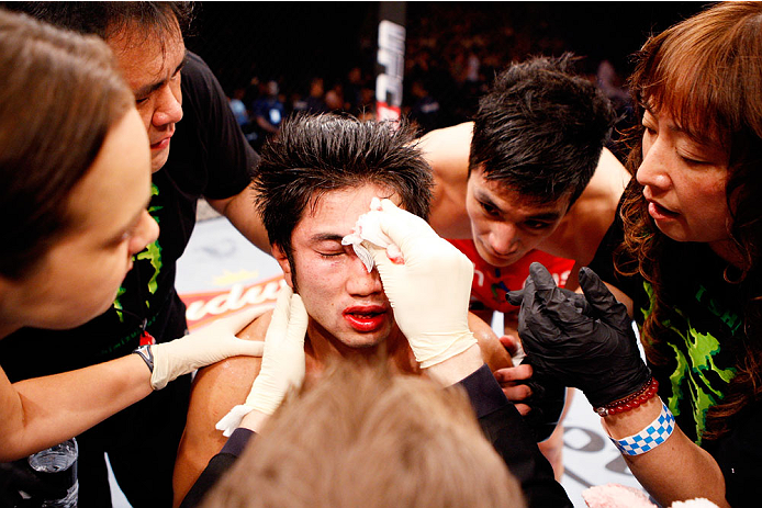 SINGAPORE - JANUARY 04: Shunichi Shimizu is looked over after his loss to Kang Kyung Ho in their bantamweight bout during the UFC Fight Night event at the Marina Bay Sands Resort on January 4, 2014 in Singapore. (Photo by Mitch Viquez/Zuffa LLC/Zuffa LLC