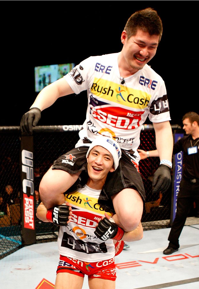 SINGAPORE - JANUARY 04: Kang Kyung Ho(below) celebrates his win over Shunichi Shimizu in their bantamweight bout during the UFC Fight Night event at the Marina Bay Sands Resort on January 4, 2014 in Singapore. (Photo by Mitch Viquez/Zuffa LLC/Zuffa LLC v