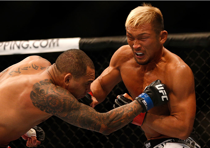 SINGAPORE - JANUARY 04: (R-L) Kiichi Kunimoto punches Luiz Dutra in their welterweight bout during the UFC Fight Night event at the Marina Bay Sands Resort on January 4, 2014 in Singapore. (Photo by Josh Hedges/Zuffa LLC/Zuffa LLC via Getty Images)
