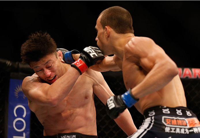 SINGAPORE - JANUARY 04: (R-L) Sean Soriano punches Tatsuya Kawajiri in their featherweight bout during the UFC Fight Night event at the Marina Bay Sands Resort on January 4, 2014 in Singapore. (Photo by Josh Hedges/Zuffa LLC/Zuffa LLC via Getty Images)
