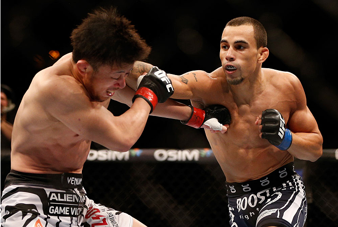 SINGAPORE - JANUARY 04: (R-L) Sean Soriano punches Tatsuya Kawajiri in their featherweight bout during the UFC Fight Night event at the Marina Bay Sands Resort on January 4, 2014 in Singapore. (Photo by Josh Hedges/Zuffa LLC/Zuffa LLC via Getty Images)