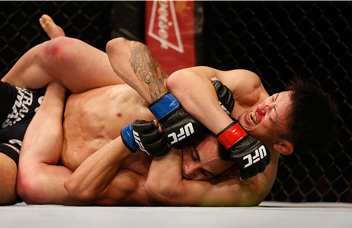SINGAPORE - JANUARY 04: (R-L) Tatsuya Kawajiri attempts to secure a rear choke submission against Sean Soriano in their featherweight bout during the UFC Fight Night event at the Marina Bay Sands Resort on January 4, 2014 in Singapore. (Photo by Josh Hed