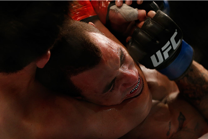 SINGAPORE - JANUARY 04: (L-R) Tatsuya Kawajiri secures a rear choke submission against Sean Soriano in their featherweight bout during the UFC Fight Night event at the Marina Bay Sands Resort on January 4, 2014 in Singapore. (Photo by Josh Hedges/Zuffa L