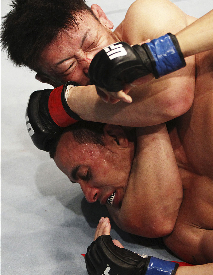 SINGAPORE - JANUARY 04: Tatsuya Kawajiri goes for a submission attempt on Sean Soriano in their featherweight bout during the UFC Fight Night event at the Marina Bay Sands Resort on January 4, 2014 in Singapore. (Photo by Mitch Viquez/Zuffa LLC/Zuffa L