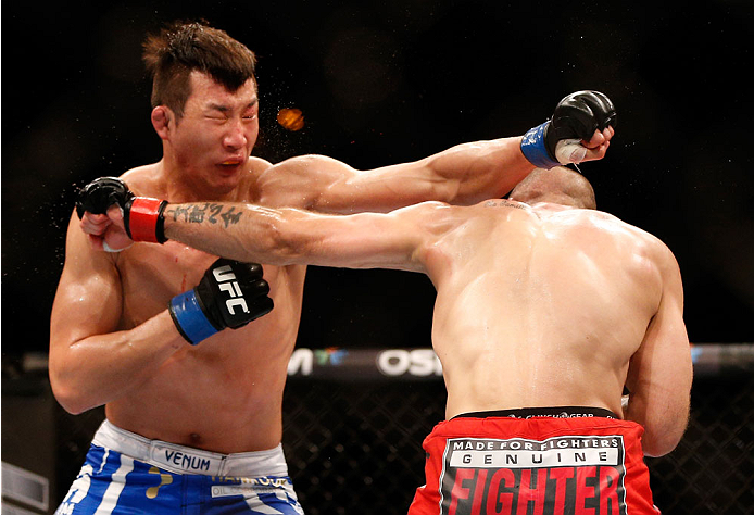 SINGAPORE - JANUARY 04: (R-L) Tarec Saffiedine and Lim Hyun Gyu trade punches in their welterweight bout during the UFC Fight Night event at the Marina Bay Sands Resort on January 4, 2014 in Singapore. (Photo by Josh Hedges/Zuffa LLC/Zuffa LLC via Getty