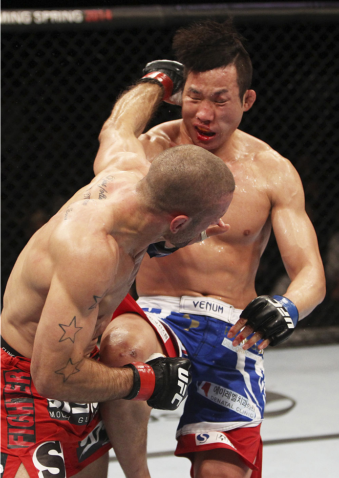 SINGAPORE - JANUARY 04: Tarec Saffiedine lands a shot on Lim Hyun Gyu in their welterweight bout during the UFC Fight Night event at the Marina Bay Sands Resort on January 4, 2014 in Singapore. (Photo by Mitch Viquez/Zuffa LLC/Zuffa LLC via Getty Images
