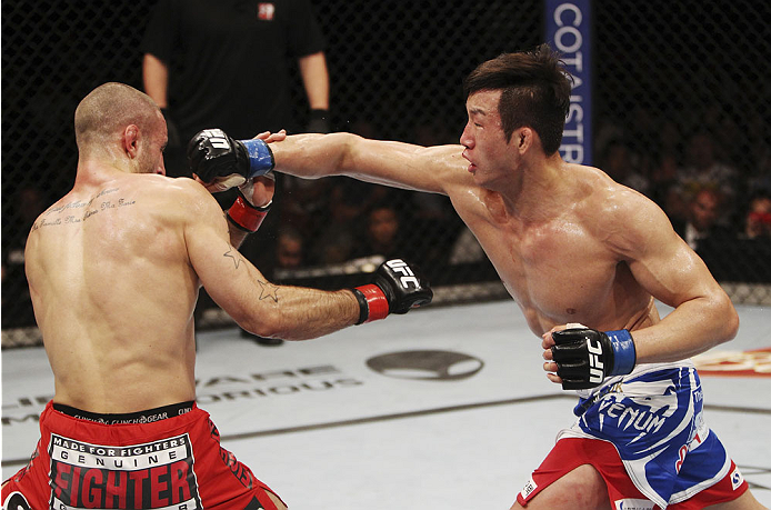 SINGAPORE - JANUARY 04: Lim Hyun Gyu throws a punch at Tarec Saffiedine in their welterweight bout during the UFC Fight Night event at the Marina Bay Sands Resort on January 4, 2014 in Singapore. (Photo by Mitch Viquez/Zuffa LLC/Zuffa LLC via Getty Image