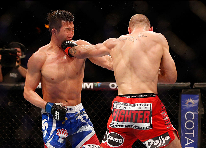 SINGAPORE - JANUARY 04: (R-L) Tarec Saffiedine punches Lim Hyun Gyu in their welterweight bout during the UFC Fight Night event at the Marina Bay Sands Resort on January 4, 2014 in Singapore. (Photo by Josh Hedges/Zuffa LLC/Zuffa LLC via Getty Images)