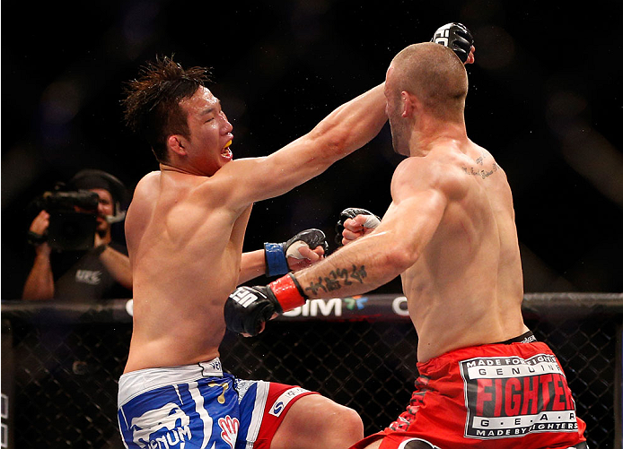 SINGAPORE - JANUARY 04: (L-R) Lim Hyun Gyu punches Tarec Saffiedine in their welterweight bout during the UFC Fight Night event at the Marina Bay Sands Resort on January 4, 2014 in Singapore. (Photo by Josh Hedges/Zuffa LLC/Zuffa LLC via Getty Images)