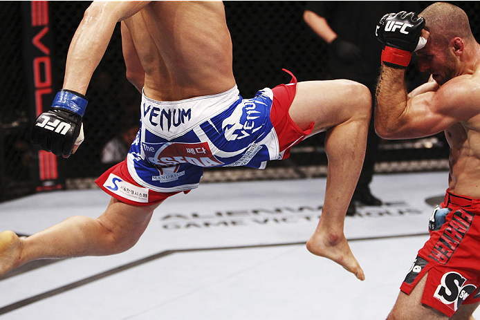 SINGAPORE - JANUARY 04: Lim Hyun Gyu goes for a flying knee on Tarec Saffiedine in their welterweight bout during the UFC Fight Night event at the Marina Bay Sands Resort on January 4, 2014 in Singapore. (Photo by Mitch Viquez/Zuffa LLC/Zuffa LLC via Get