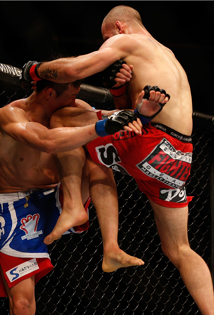 SINGAPORE - JANUARY 04: (R-L) Tarec Saffiedine knees Lim Hyun Gyu in their welterweight bout during the UFC Fight Night event at the Marina Bay Sands Resort on January 4, 2014 in Singapore. (Photo by Josh Hedges/Zuffa LLC/Zuffa LLC via Getty Images)