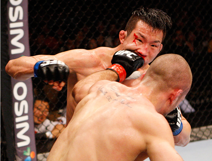 SINGAPORE - JANUARY 04: Tarec Saffiedine lands a shot on Lim Hyun Gyu in their welterweight bout during the UFC Fight Night event at the Marina Bay Sands Resort on January 4, 2014 in Singapore. (Photo by Mitch Viquez/Zuffa LLC/Zuffa LLC via Getty Images
