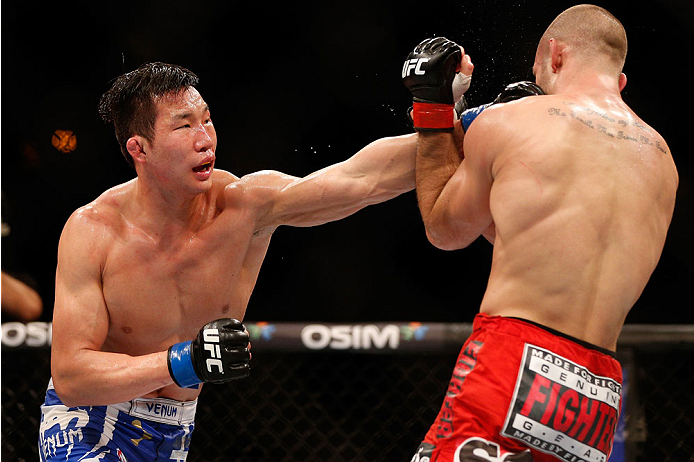 SINGAPORE - JANUARY 04: (L-R) Lim Hyun Gyu punches Tarec Saffiedine in their welterweight bout during the UFC Fight Night event at the Marina Bay Sands Resort on January 4, 2014 in Singapore. (Photo by Josh Hedges/Zuffa LLC/Zuffa LLC via Getty Images)