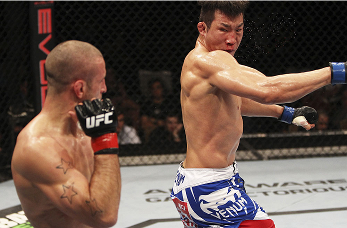 SINGAPORE - JANUARY 04: Lim Hyun Gyu goes for a spinning back fist on Tarec Saffiedine in their welterweight bout during the UFC Fight Night event at the Marina Bay Sands Resort on January 4, 2014 in Singapore. (Photo by Mitch Viquez/Zuffa LLC/Zuffa LLC