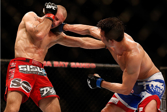 SINGAPORE - JANUARY 04: (R-L) Lim Hyun Gyu punches Tarec Saffiedine in their welterweight bout during the UFC Fight Night event at the Marina Bay Sands Resort on January 4, 2014 in Singapore. (Photo by Josh Hedges/Zuffa LLC/Zuffa LLC via Getty Images)