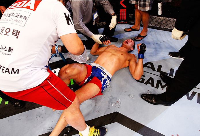 SINGAPORE - JANUARY 04: Lim Hyun Gyu lays on the ground after a five round fight with Tarec Saffiedine their welterweight bout during the UFC Fight Night event at the Marina Bay Sands Resort on January 4, 2014 in Singapore. (Photo by Mitch Viquez/Zuffa
