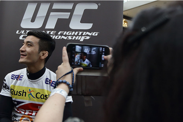 SINGAPORE - JANUARY 02: A lady takes a photo of Kyung Ho Kang during the UFC Fight Night Singapore Ultimate Media Day at the Skating Rink at The Shoppes at Marina Bay Sand on January 2, 2014 in Singapore. (Photo by Suhaimi Abdullah/Zuffa LLC)
