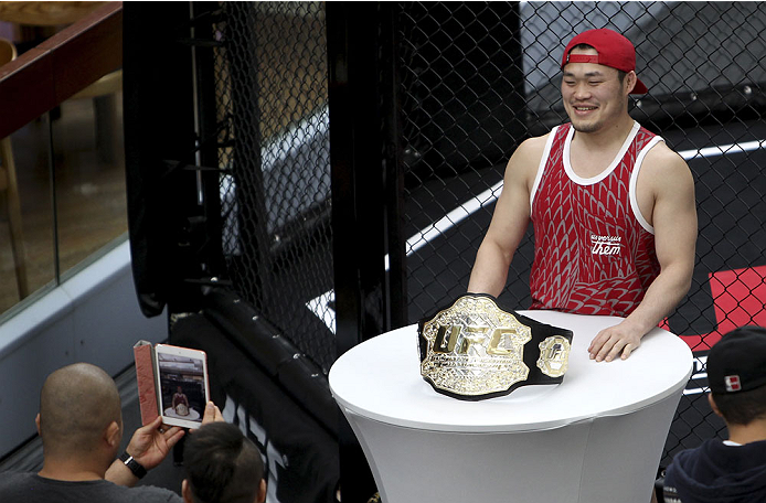SINGAPORE - JANUARY 02: A fan poses with the UFC championship belt during the UFC Fight Night Singapore Ultimate Media Day at the Shoppes at Marina Bay Sands on January 2, 2014 in Singapore. (Photo by Mitch Viquez/Zuffa LLC/Zuffa LLC via Getty Images)