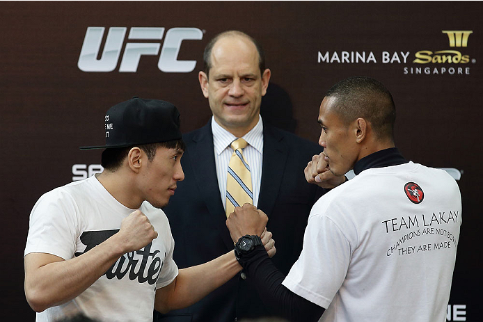 SINGAPORE - JANUARY 02: Royston Wee (L) faces off with David Galera (R) as Mark Fischer (C), Managing Director of UFC Asia looks on during the UFC Fight Night Singapore Ultimate Media Day at the Skating Rink at The Shoppes at Marina Bay Sand on January 2