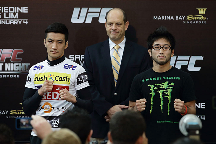 SINGAPORE - JANUARY 02: Kyung Ho Kang (L) and Shunichi Shimizu (R) pose for a photo as Mark Fischer (C), managing director of UFC Asia, looks on during the UFC Fight Night Singapore Ultimate Media Day at the Skating Rink at The Shoppes at Marina Bay Sand