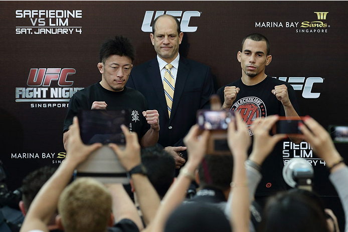 SINGAPORE - JANUARY 02: Kyung Ho Kang (L) and Shunichi Shimizu (R) pose for a photo as Mark Fischer (C), managing director of UFC Asia, looks on during the UFC Fight Night Singapore Ultimate Media Day at the Skating Rink at The Shoppes at Marina Bay Sand