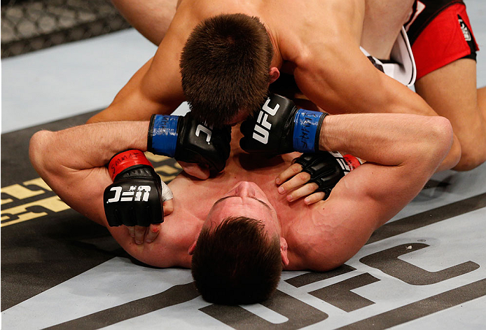 STOCKHOLM, SWEDEN - OCTOBER 04: Scott Askham (bottom) of England lands a double punch against opponent Magnus Cedenblad of Sweden in their middleweight bout at the Ericsson Globe Arena on October 4, 2014 in Stockholm, Sweden. (Photo by Josh Hedges/Zuffa