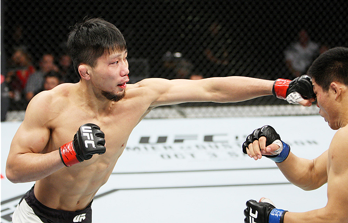 SAITAMA, JAPAN - SEPTEMBER 27: Keita Nakamura of Japan punches Li Jingliang of China in their welterweight bout during the UFC event at the Saitama Super Arena on September 27, 2015 in Saitama, Japan. (Photo by Mitch Viquez/Zuffa LLC/Zuffa LLC via Getty