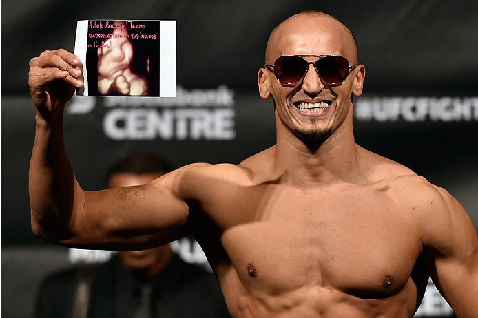 HALIFAX, NS - OCTOBER 3: Yosdenis Cedeno of Cuba holds a photo of his baby's sonogram as he steps on the scale during the UFC Fight Night weigh-in at the Scotiabank Centre on October 3, 2014 in Halifax, Nova Scotia, Canada. (Photo by Jeff Bottari/Zuffa L