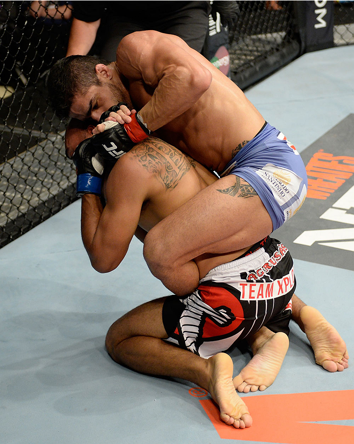 BANGOR, ME - AUGUST 16: (R-L) Thiago Tavares attempts a rear naked choke submission against Robbie Peralta in their featherweight bout during the UFC fight night event at the Cross Insurance Center on August 16, 2014 in Bangor, Maine. (Photo by Jeff Bott