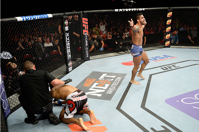 BANGOR, ME - AUGUST 16: (R-L) Thiago Tavares celebrates after completing a rear naked choke submission against Robbie Peralta in their featherweight bout during the UFC fight night event at the Cross Insurance Center on August 16, 2014 in Bangor, Maine.