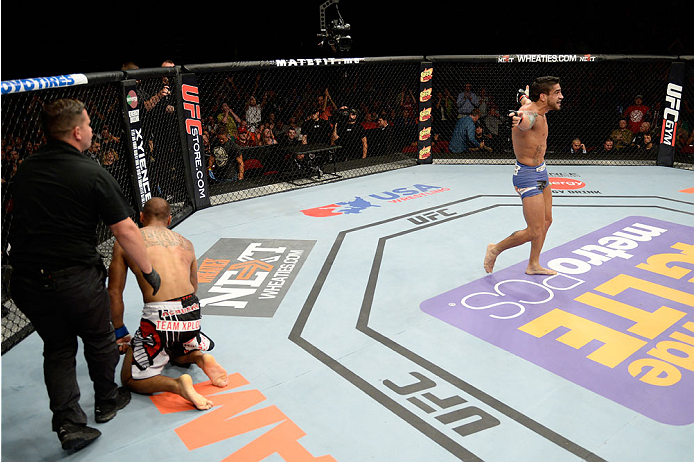 BANGOR, ME - AUGUST 16: (R-L) Thiago Tavares celebrates after completing a rear naked choke submission against Robbie Peralta in their featherweight bout during the UFC fight night event at the Cross Insurance Center on August 16, 2014 in Bangor, Maine.