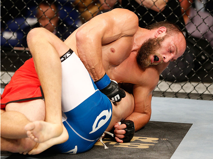 DUBLIN, IRELAND - JULY 19: Trevor Smith (red trunks) punches the body of Tor Troeng in their middleweight bout during the UFC Fight Night event at The O2 Dublin on July 19, 2014 in Dublin, Ireland. (Photo by Josh Hedges/Zuffa LLC/Zuffa LLC via Getty Ima
