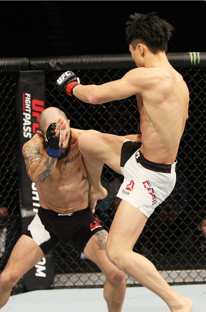 SEOUL, SOUTH KOREA - NOVEMBER 28: Doo Ho Choi of South Korea goes for a jumping strike on Sam Sicilia of the United States of America in their featherweight bout during the UFC Fight Night at the Olympic Park Gymnastics Arena on November 28, 2015 in Seou