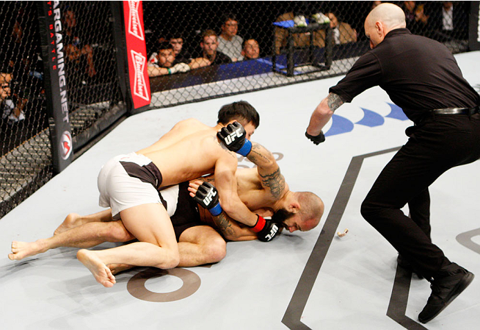 SEOUL, SOUTH KOREA - NOVEMBER 28: Doo Ho Choi of South Korea punches Sam Sicilia of the United States of America before the referee stops the fight due to TKO in their featherweight bout during the UFC Fight Night at the Olympic Park Gymnastics Arena on